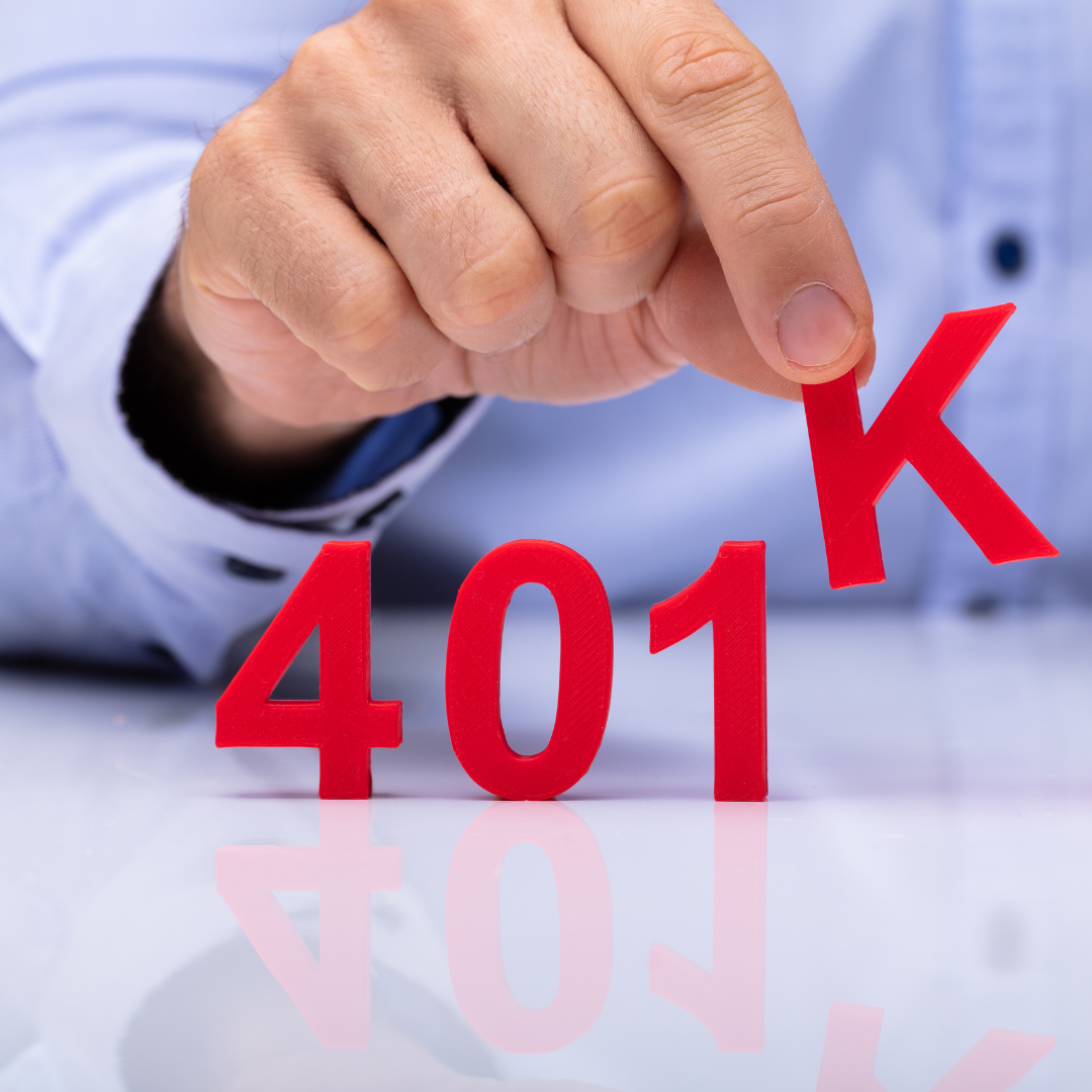 Red blocks that say 401k, with a man's hand picking up the K